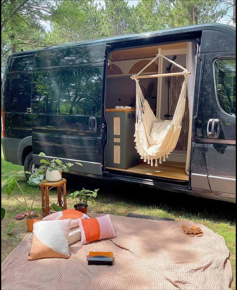 RV rental: Black camper van with open door, featuring a hanging chair & cozy outdoor picnic setup on grass. Perfect for nature escapes. — photo 7
