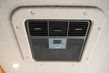 A Dometic RV air conditioner with adjustable vents and digital controls mounted on a textured ceiling, common in an rv rental.