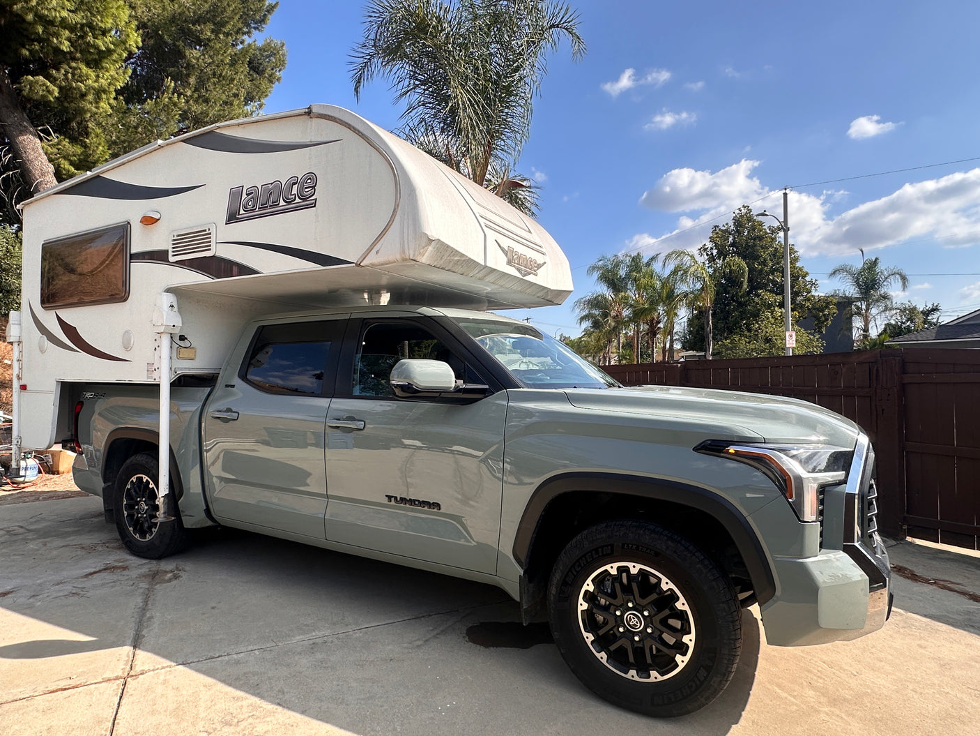 A grey Toyota Tundra pickup truck with a white Lance truck camper, ideal for your next RV rental adventure.