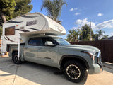 A grey Toyota Tundra pickup truck with a white Lance truck camper, ideal for your next RV rental adventure.