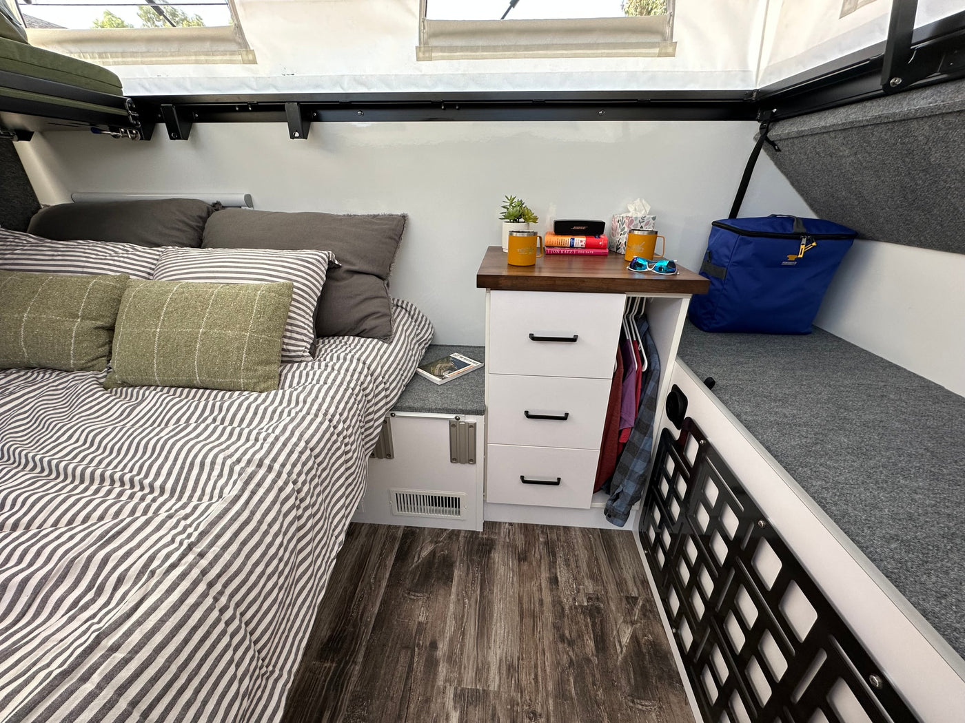 Cozy RV rental bedroom with striped bed, practical nightstand, and smart storage bench for a comfortable travel experience. — photo 4