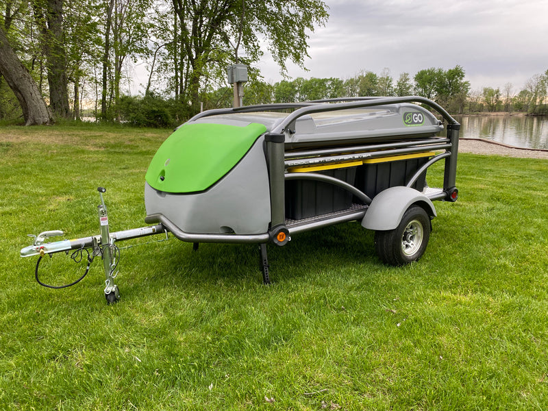 SylvanSport Go compact camper for RV rental, parked on lush grass by a tranquil lake. — photo 2
