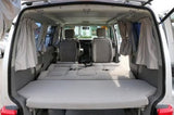 RV rental interior: rear seats fold flat, forming a spacious bed. Ideal camper van for road trips.