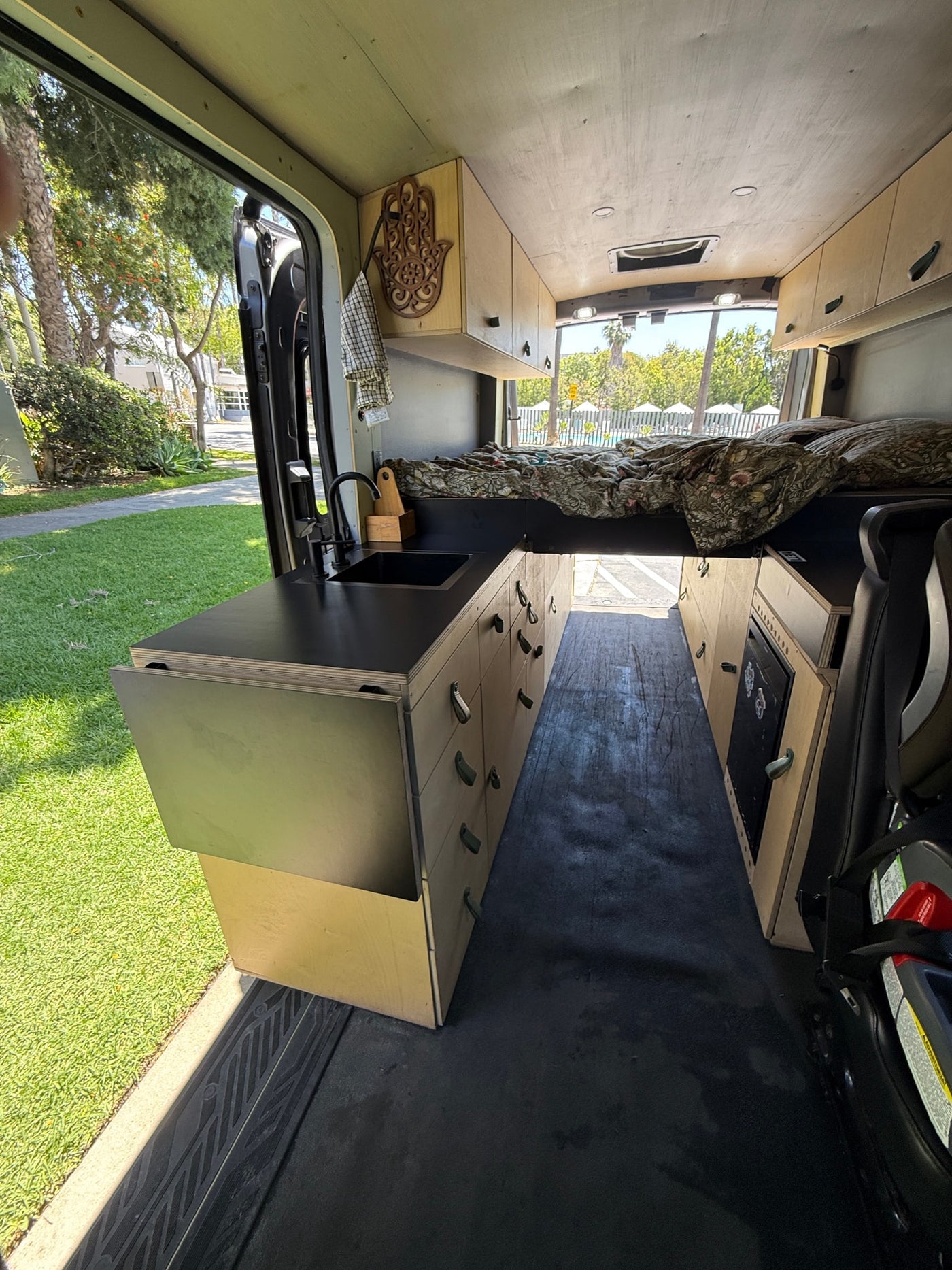 RV rental: Modern kitchen with sink, fold-out counter, comfy bed, storage cabinets, and outdoor views for adventures. — photo 9