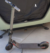 An electric scooter is parked near an RV rental, a Happier Camper, for convenient exploration.