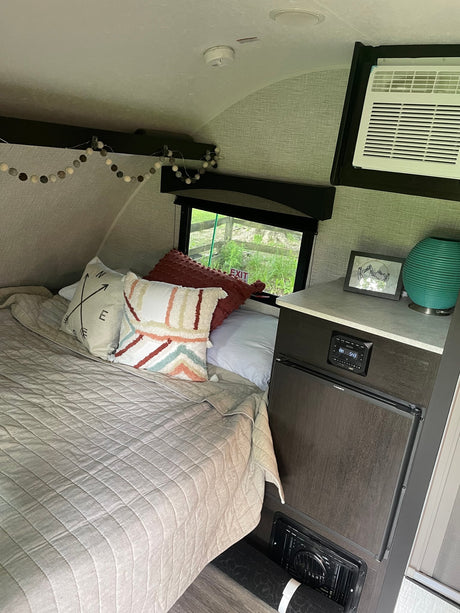 RV rental: Cozy compact sleeping area featuring a comfy bed with decorative pillows
