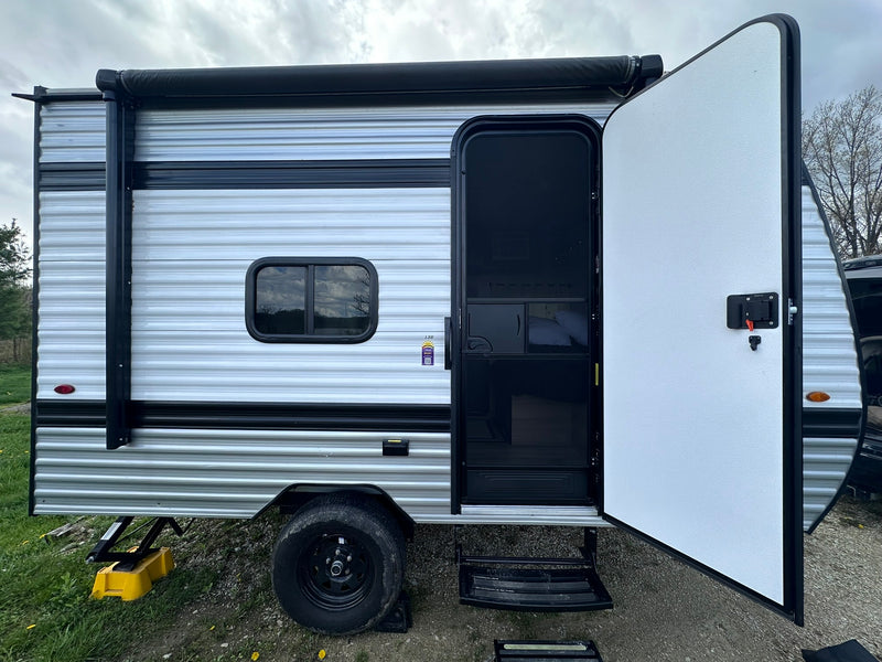 An RV rental travel trailer is shown with its main door open — photo 1