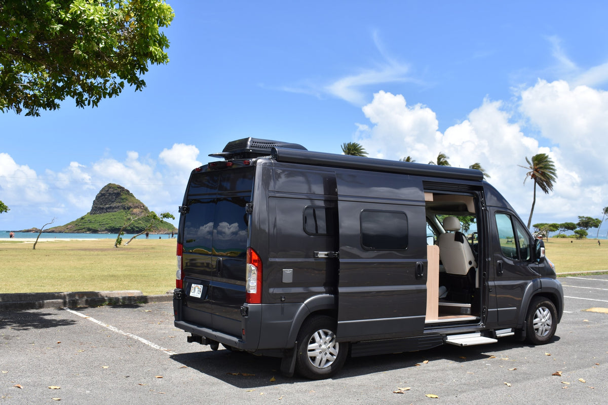 Dark gray camper van rv rental with open side door, parked overlooking Hawaii's iconic Chinaman's Hat island and a sunny beach. — photo 3
