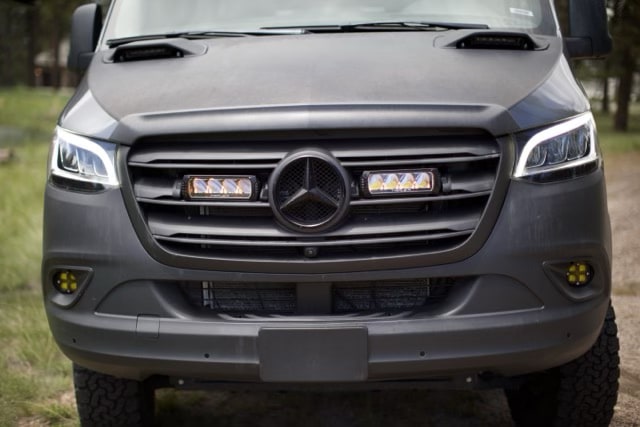  ready for exploration with its extended awning.|Rugged black all-terrain tire and wheel on an RV rental van — photo 5