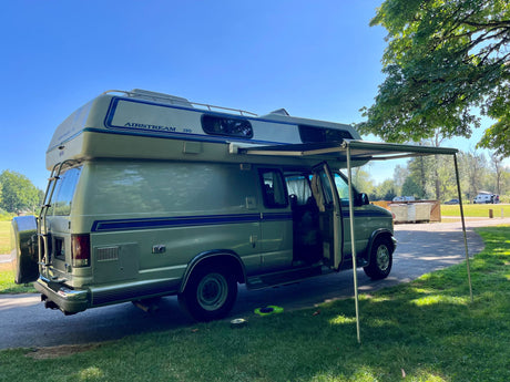 Light green Airstream 190 camper van with extended awning, ideal for your next RV rental adventure.