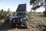 An overlanding Toyota 4Runner with roof-top tent deployed. Like an rv rental, it's set for off-road camping.
