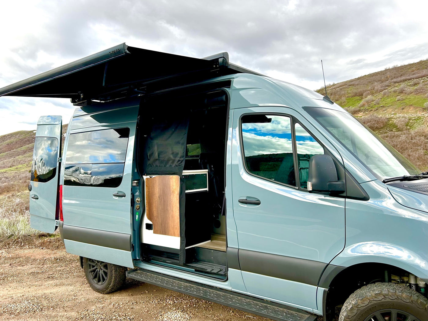 Light blue custom camper van with open doors and extended awning, ready for your next rv rental adventure. — photo 11