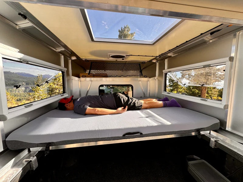  and Jackery power in snow. Perfect for an RV rental adventure.|Scenic RV rental adventure: A man naps comfortably in a camper bed — photo 1