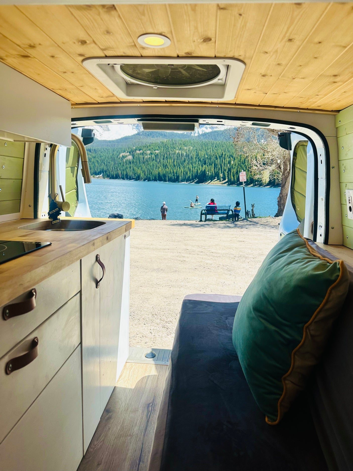 Enjoying a stunning lake view from an RV rental, complete with a cozy interior, kitchen, and nature's beauty.