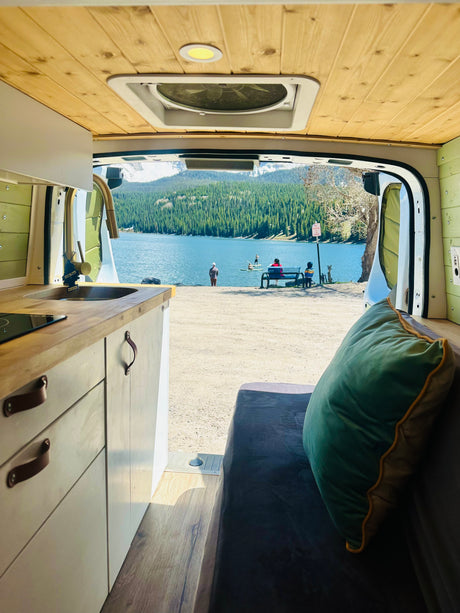 Enjoying a stunning lake view from an RV rental, complete with a cozy interior, kitchen, and nature's beauty.
