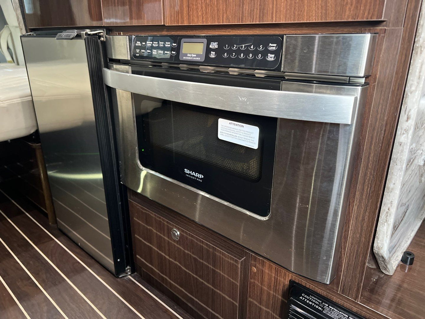 Compact kitchen in an RV rental showing a built-in microwave drawer and refrigerator for convenient use.