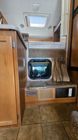 RV rental interior: bunk bed, window to the cab, and control panel with a CO detector. Ready to go!