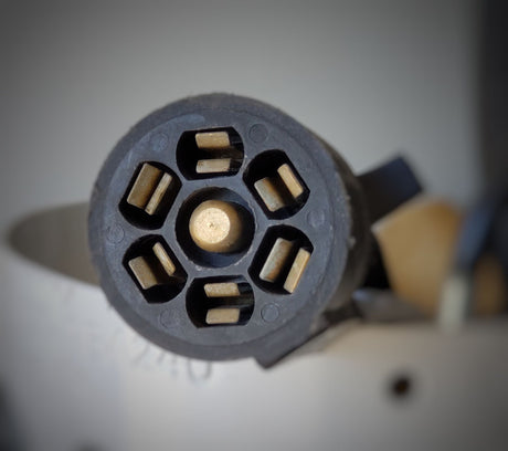 A black 7-pin electrical trailer connector. Essential for connecting an RV rental to a towing vehicle for lights and power.