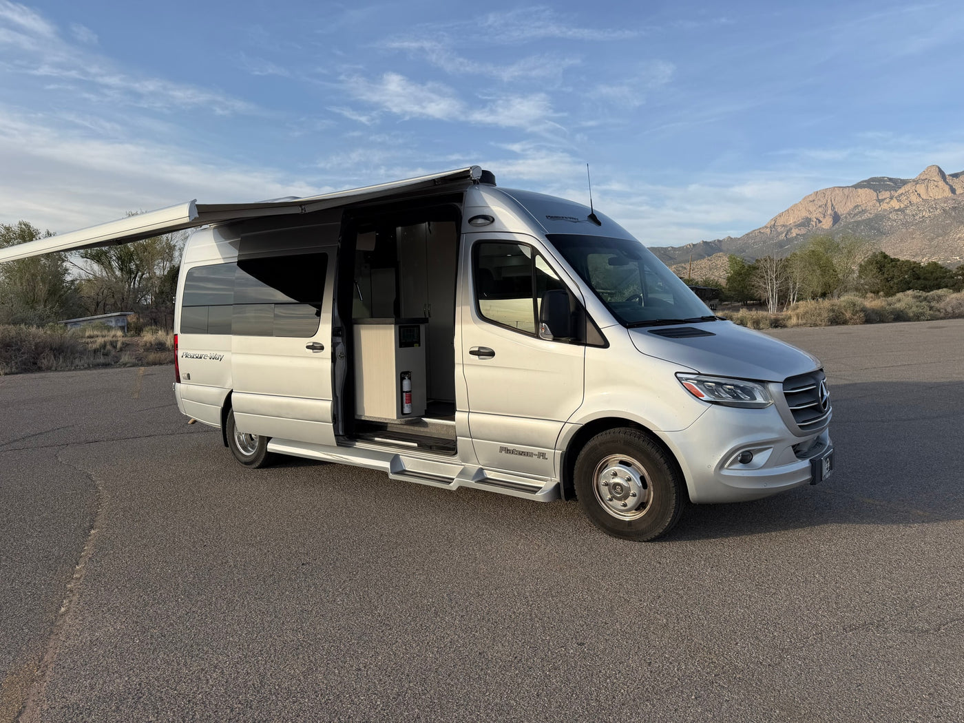 Silver Pleasure-Way Plateau-FL Mercedes-Benz Sprinter rv rental with open door & extended awning, parked with mountains. — photo 5