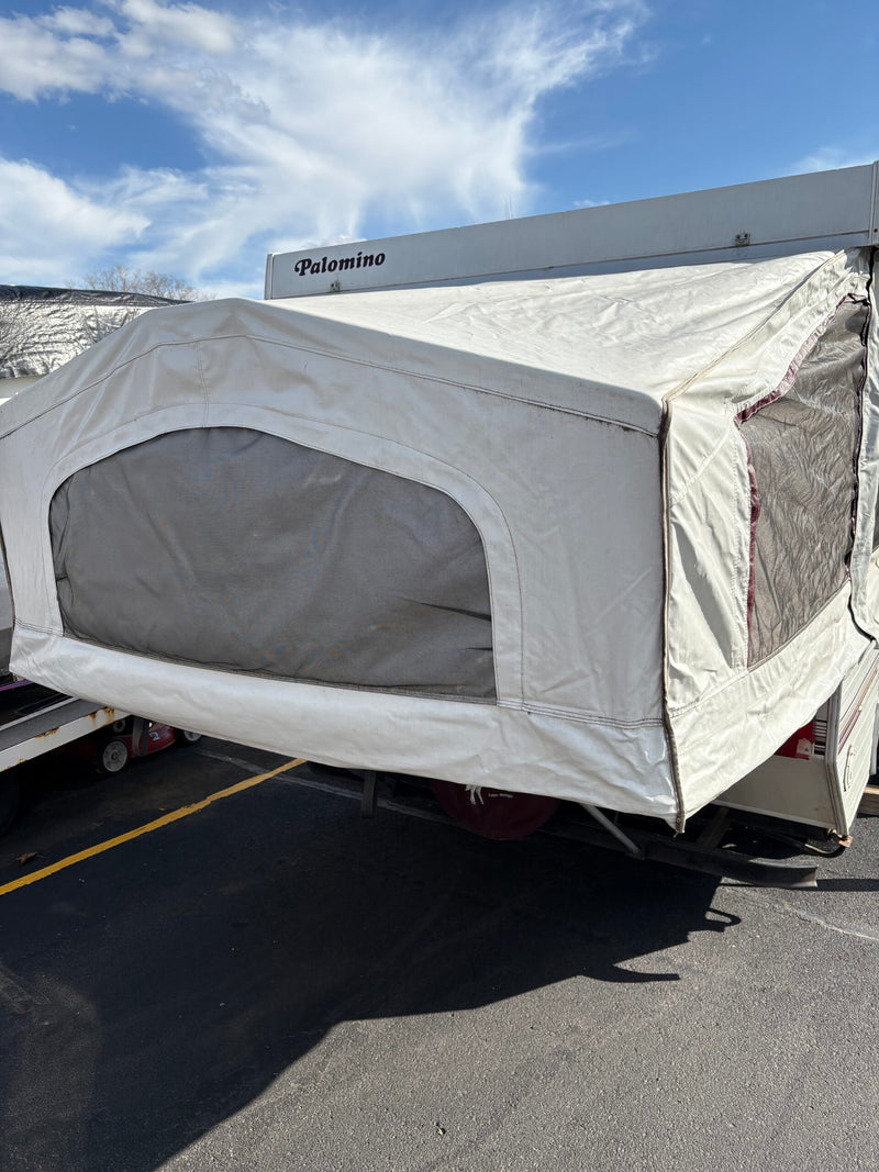 Palomino pop-up RV rental with canvas extension and mesh windows, parked on asphalt under a blue sky. — photo 4