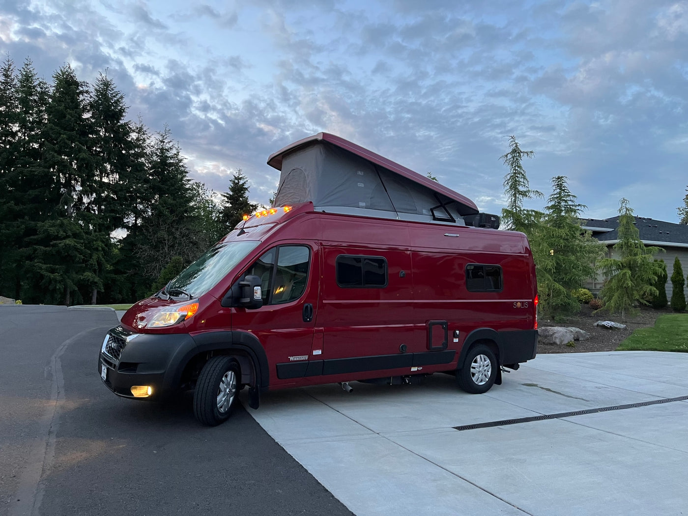 Vibrant red Winnebago Solis pop-top camper van, ideal for your next rv rental trip. — photo 2