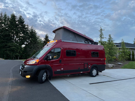 Vibrant red Winnebago Solis pop-top camper van, ideal for your next rv rental trip.