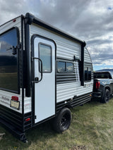 Wayfinder travel trailer RV rental, a Skybreaker model, hitched to a truck on grass, perfect for your next outdoor trip.