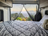  with a wooded road ahead.|Cozy RV rental interior featuring comfortable seating