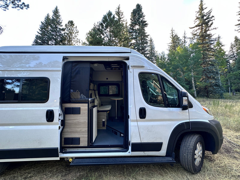  winding road through a vibrant autumn forest. Ideal for scenic drives.|RV rental: White camper van with side door open — photo 5