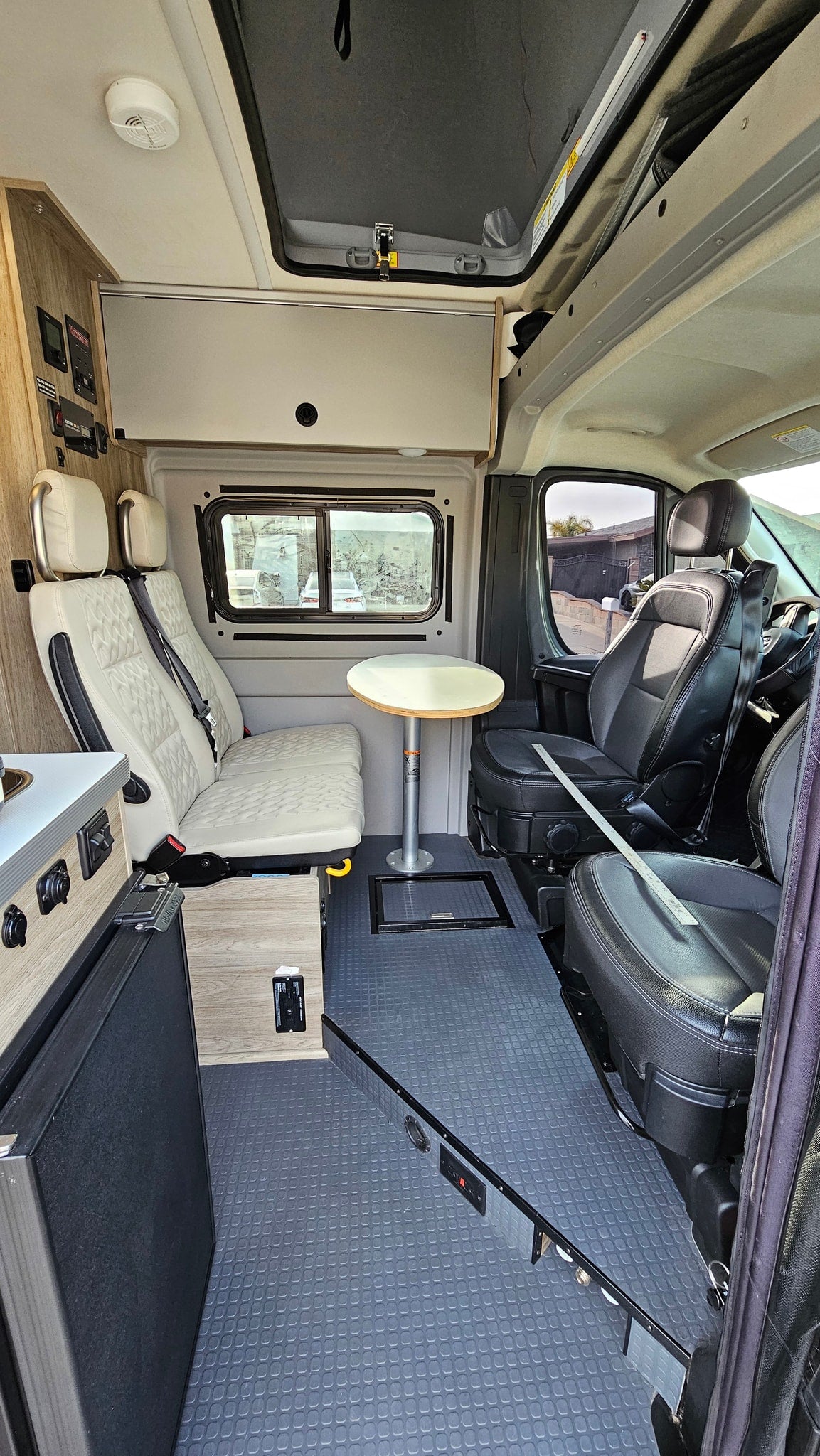 Inside a modern RV rental: kitchen, comfortable passenger seating, and dining table. Ideal for compact travel. — photo 9