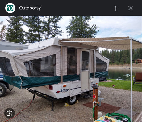 This pop-up camper RV rental offers a perfect lakeside retreat, complete with an awning for shade.