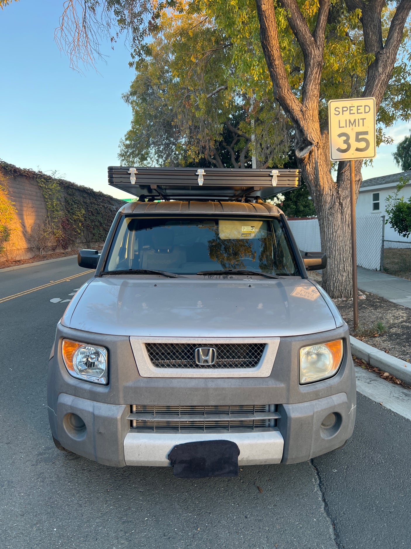 Front view of a silver Honda Element with a rooftop tent, ideal for your next compact RV rental or camping adventure.
