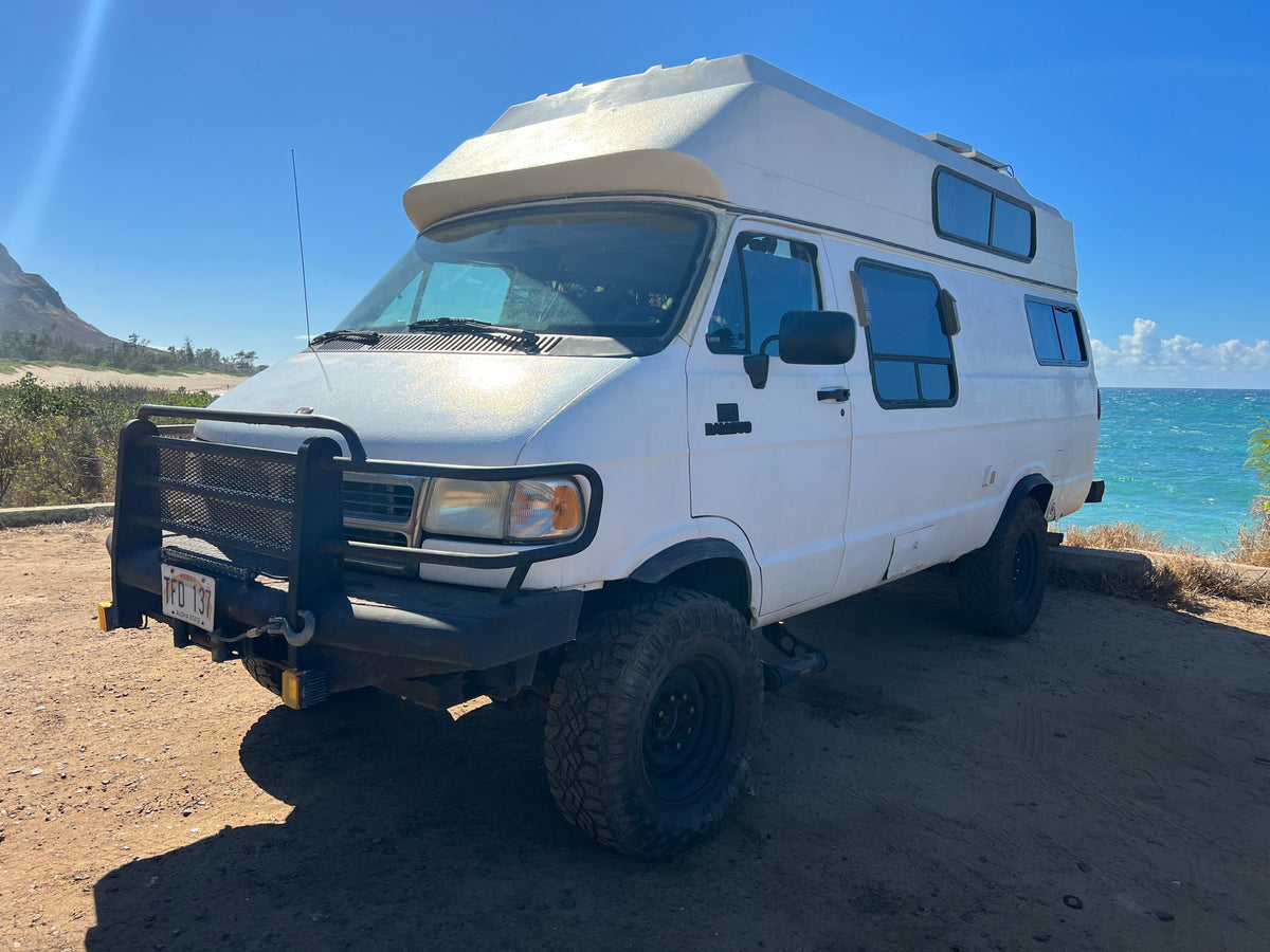  parked on a dirt lot by the ocean.|Off-road RV rental camper van — photo 5