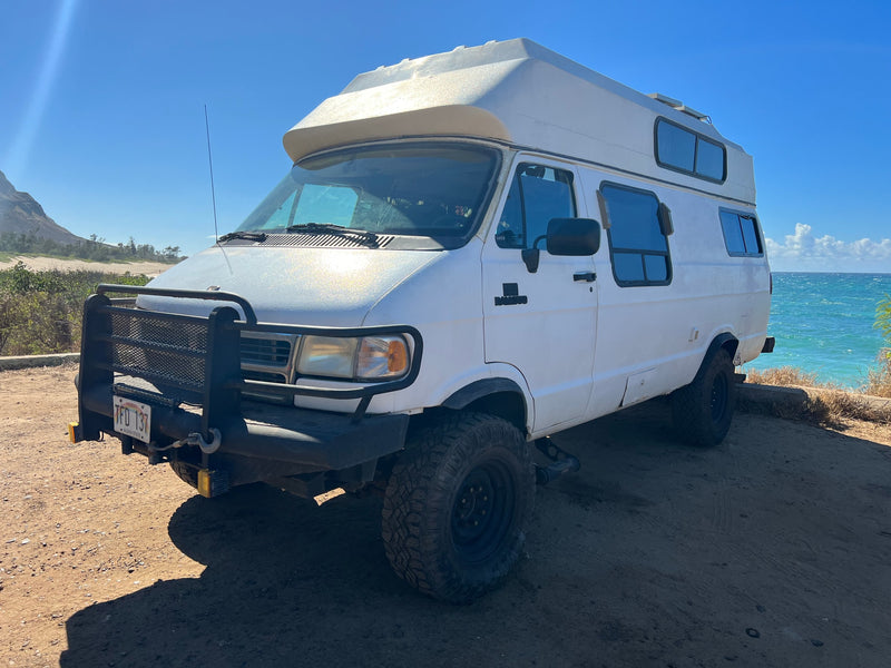  parked on a dirt lot by the ocean.|Off-road RV rental camper van — photo 5