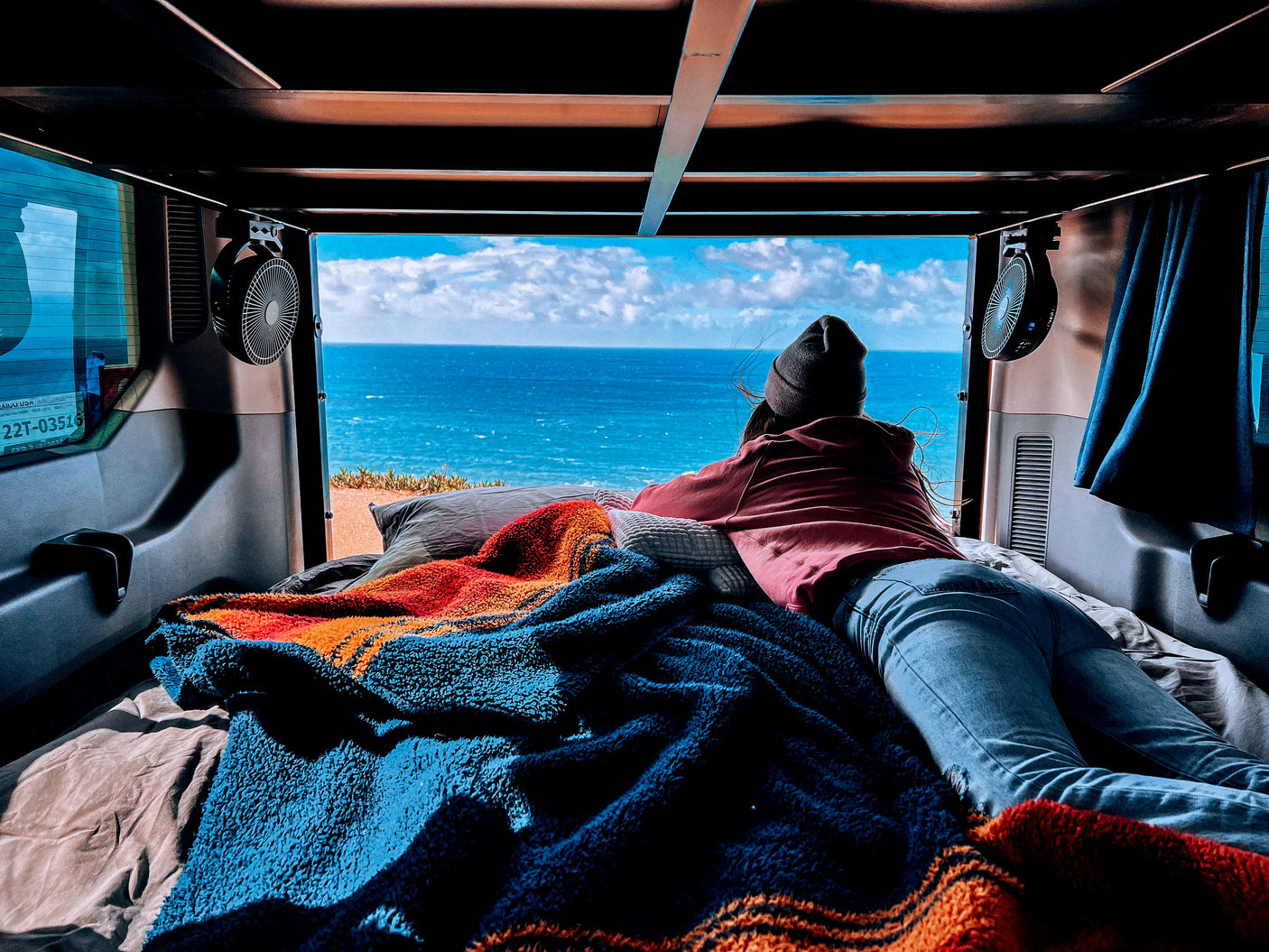 Relaxing with an ocean view from a cozy rv rental, perfect for van life relaxation.