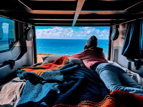 Relaxing with an ocean view from a cozy rv rental, perfect for van life relaxation.