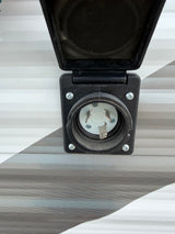 Close-up of a 30 Amp twist-lock shore power inlet on an RV rental, essential for connecting to campsite electricity.