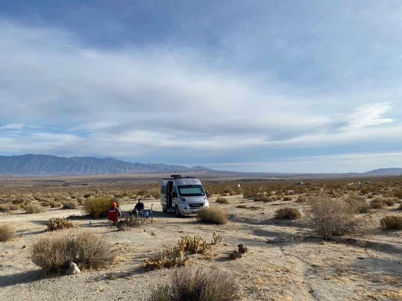 Enjoying a serene desert RV rental camp, with mountains in the distance and wide open skies. Perfect outdoor escape!