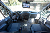 Interior of an RV rental van, highlighting the dashboard, steering wheel, and a monitor displaying multiple camera views for parking.