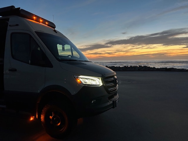  and warm campfire at sunset.|Scenic RV rental adventure: A white Winnebago Revel van is parked by lush vineyard rows — photo 3