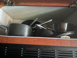 RV rental kitchen: pots and pans efficiently stored in a compact cabinet, ready for cooking adventure.