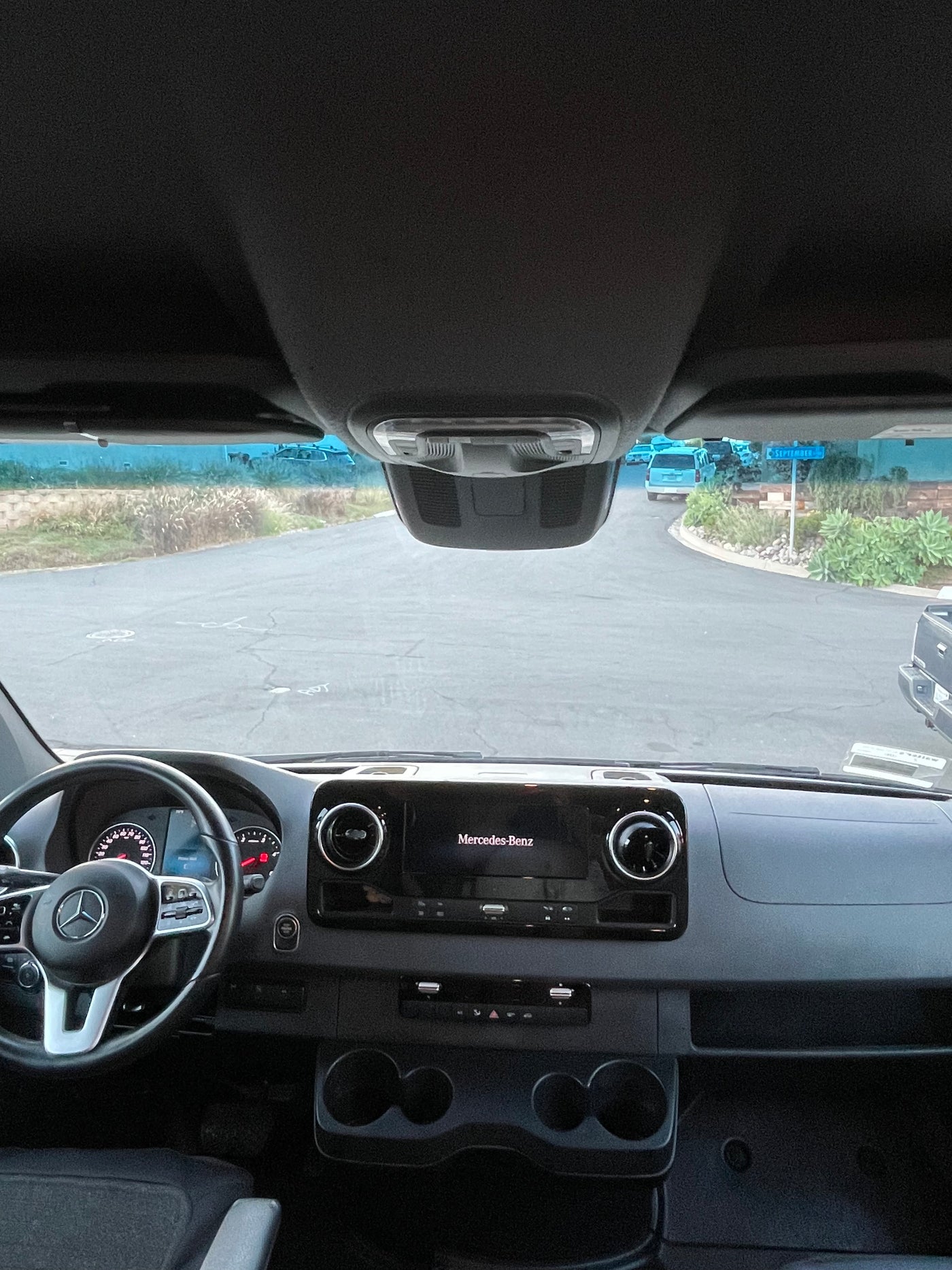 Driver's view from a Mercedes-Benz Sprinter RV rental: dashboard, steering wheel, and road outside. — photo 11
