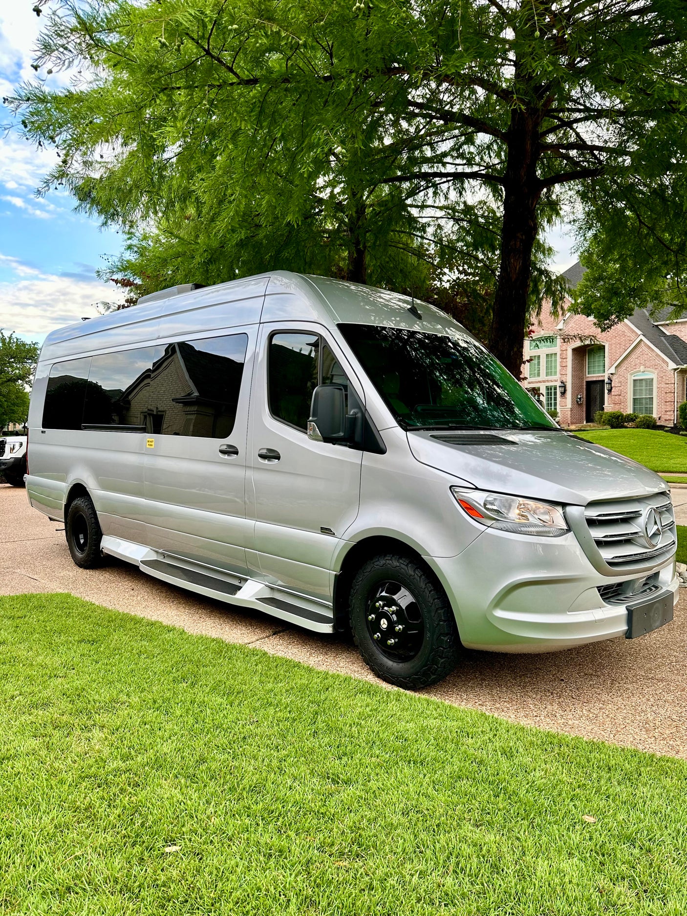 Silver Mercedes-Benz Sprinter van, an excellent RV rental option, parked on a residential driveway.