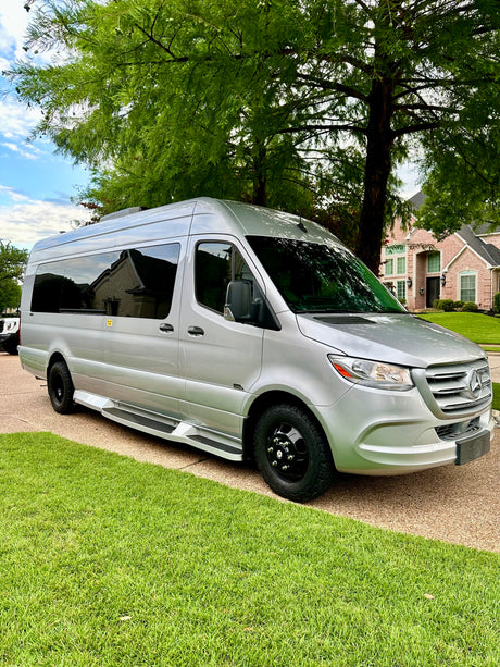 Silver Mercedes-Benz Sprinter van, an excellent RV rental option, parked on a residential driveway.