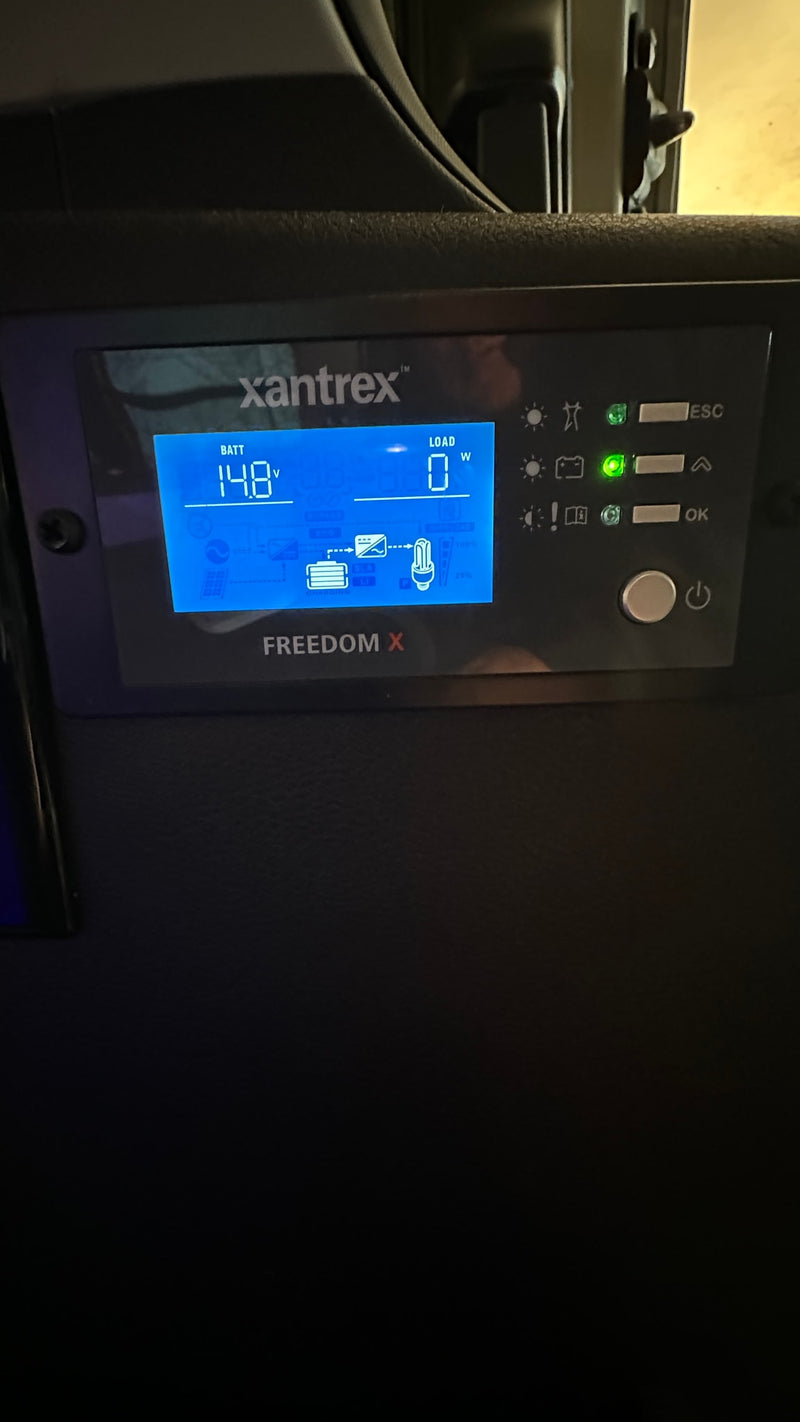 This Xantrex Freedom X inverter display in an RV rental shows 14.8V battery and 0W load, monitoring the electrical system in a camper. — photo 10
