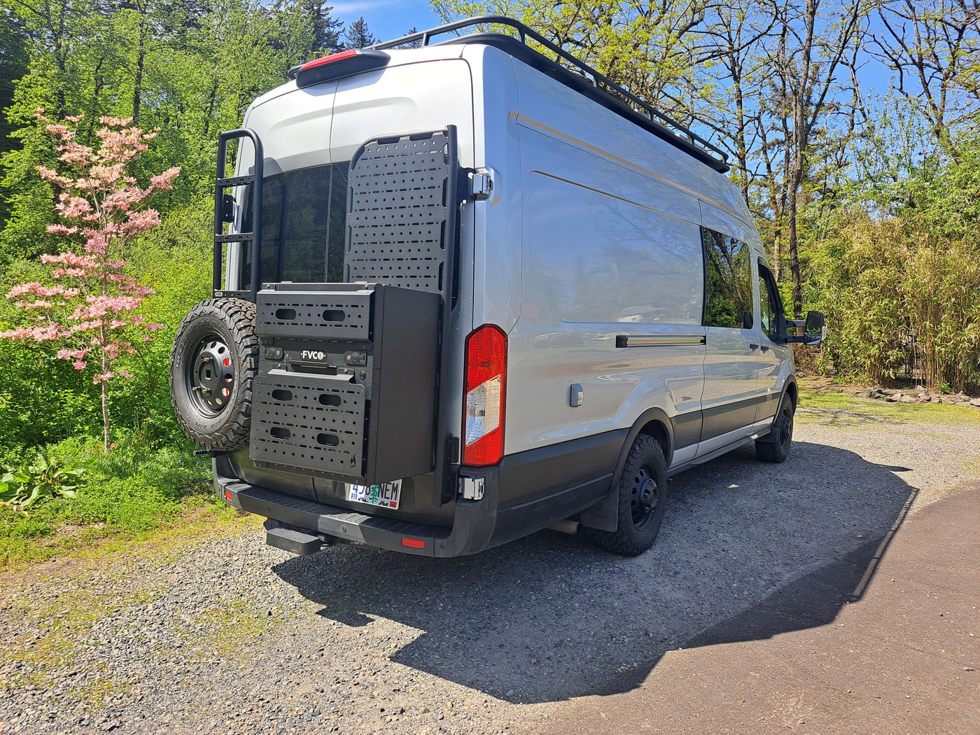 Silver camper van, equipped for adventure, seen from rear-right. Ideal for RV rental. Features roof rack, ladder, and rear storage. — photo 16