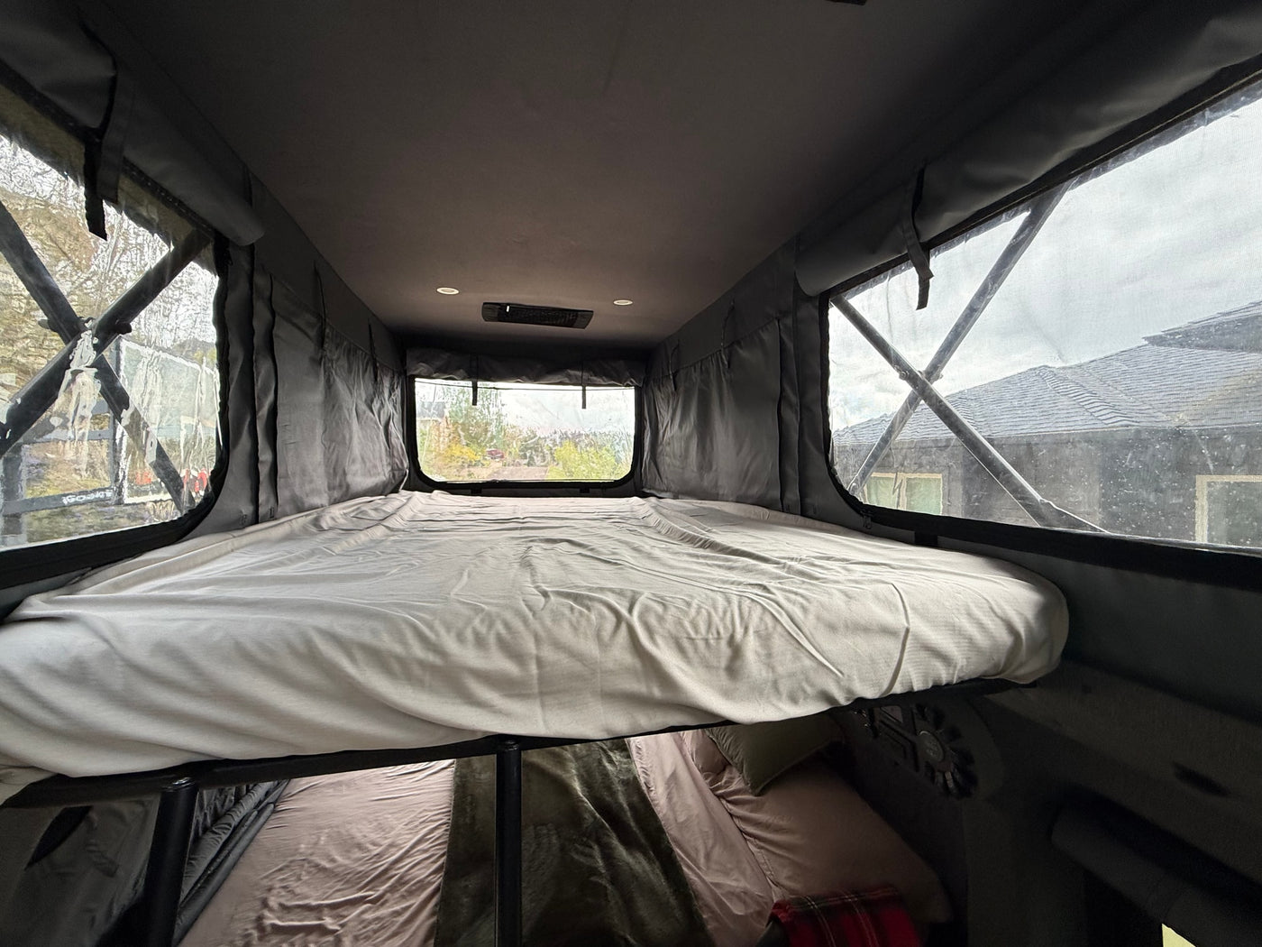 Cozy upper and lower bunk beds in an rv rental, with large windows for natural light. Ideal for mobile living and travel. — photo 19