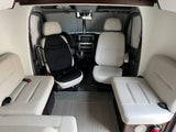 Spacious RV rental interior featuring swiveling front seats and two rear passenger benches.