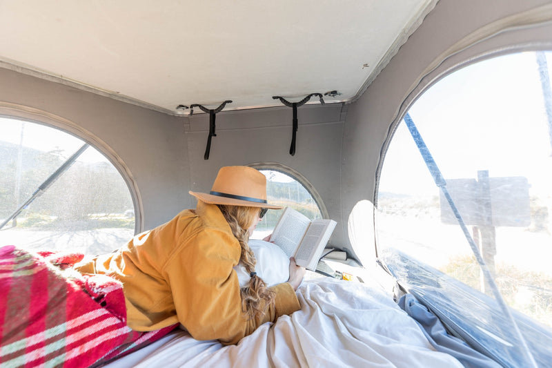  looking at trees from inside his camper van.|A person's hands adjust a black panel inside an rv rental — photo 14