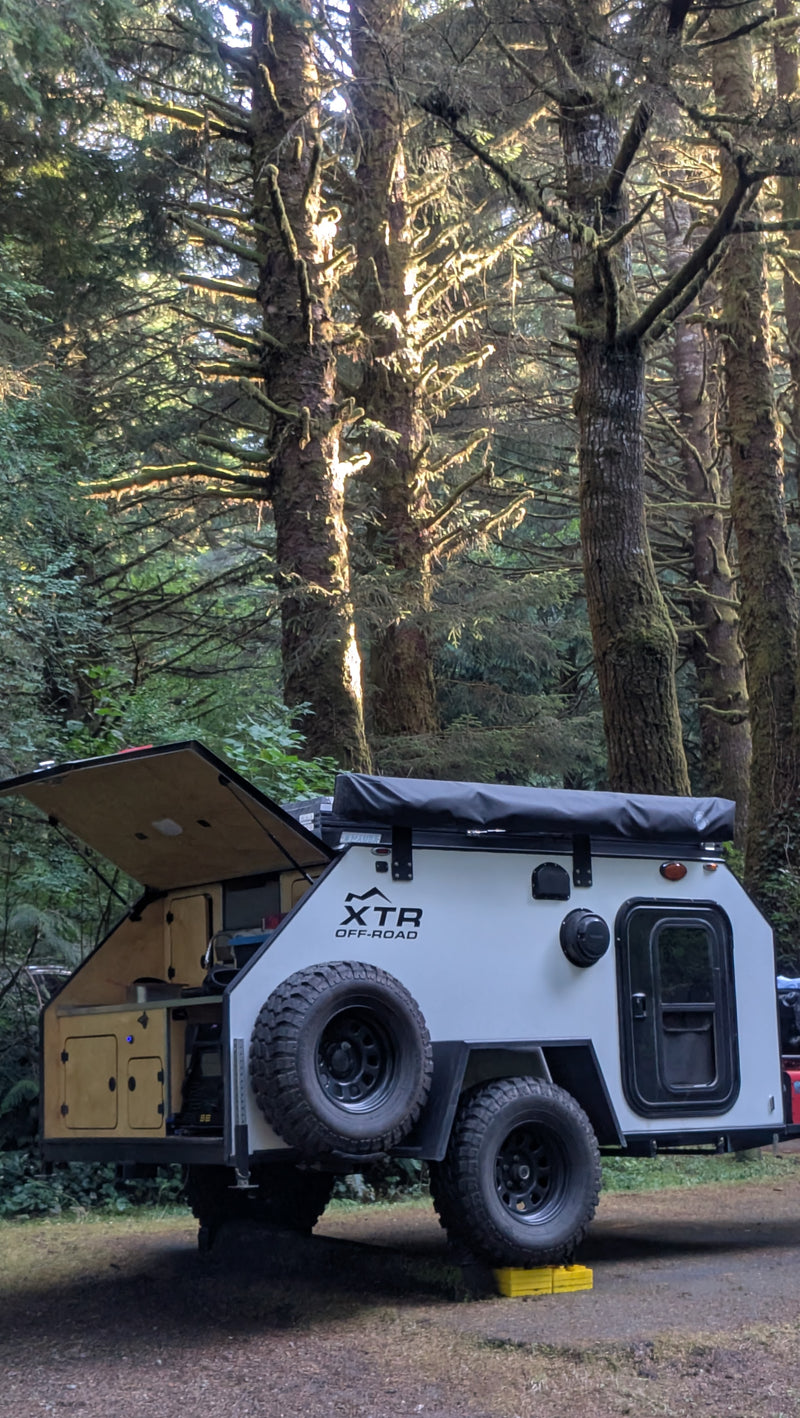 Explore nature with this XTR off-road teardrop RV rental, ideal for rugged trails & forest camping. Hatch open, kitchen visible. — photo 9